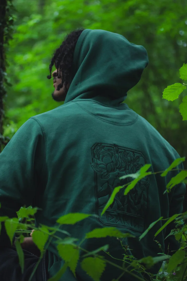 Un homme de dos portant le sweat inspiré de la terre regarde pensivement vers le ciel