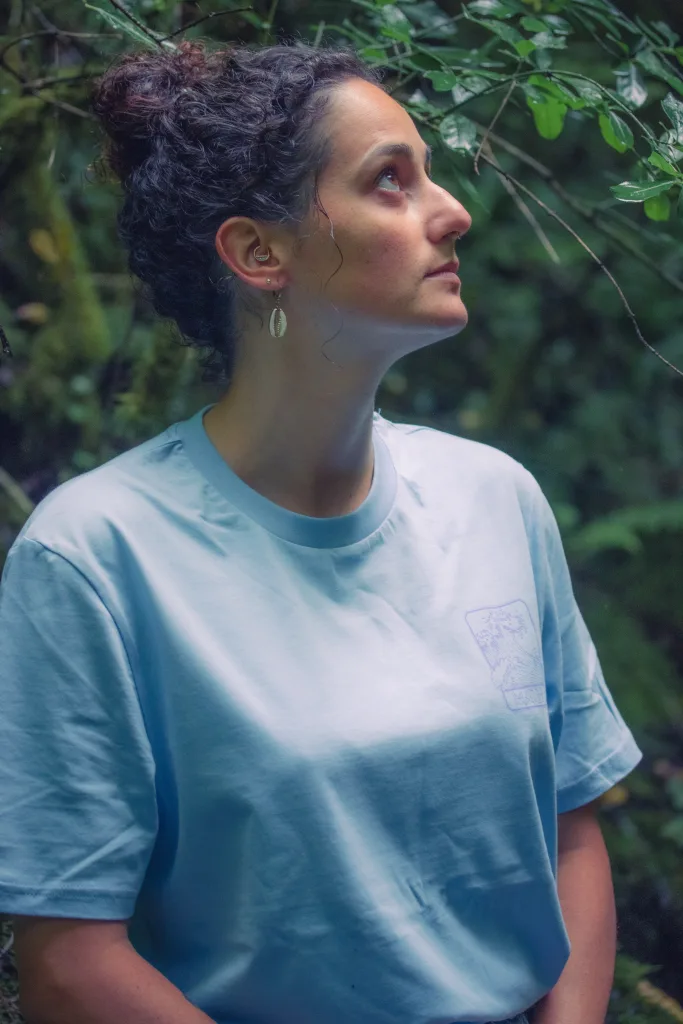 Photo de mise en situation d'une femme portant le t-shirt de l'eau WATER de profil regardant vers le ciel dans la nature